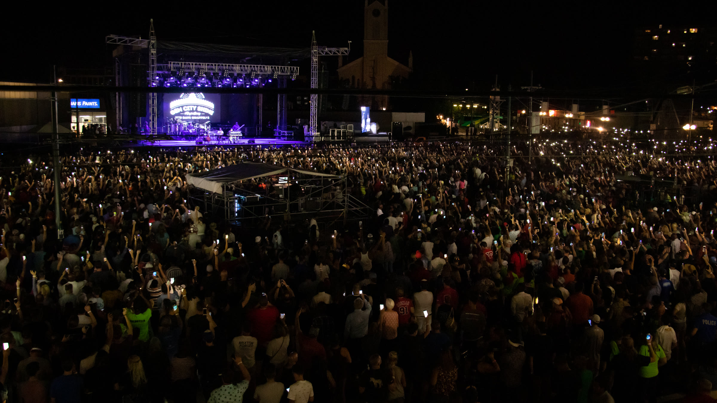 Elevated view of a packed nighttime outdoor concert